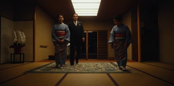 Movie still from “Tokyo Vice” (2022), created by J.T. Rogers – Two women and a man standing on a rug; Medium shot, Low angle