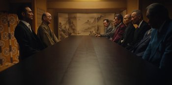 Movie still from “Tokyo Vice” (2022), created by J.T. Rogers – A group of people sitting around a table talking to each other; Wide shot, High angle