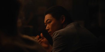 Movie still from “Tokyo Vice” (2022), created by J.T. Rogers – A man holding a cell phone while sitting down; Close Up shot, Over the shoulder angle