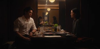 Movie still from “Tokyo Vice” (2022), created by J.T. Rogers – A man and a woman sitting at a table in a restaurant; Medium shot, Over the shoulder angle