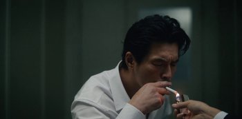 Movie still from “Tokyo Vice” (2022), created by J.T. Rogers – A man in a white shirt is lighting a cigarette; Close Up shot, High angle