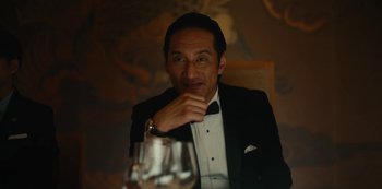 Movie still from “Tokyo Vice” (2022), created by J.T. Rogers – A man sitting at a table with a glass of wine in front of him; Close Up shot, Low angle