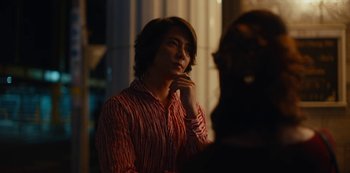Movie still from “Tokyo Vice” (2022), created by J.T. Rogers – A man in a red shirt is sitting down; Close Up shot, Over the shoulder angle