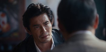 Movie still from “Tokyo Vice” (2022), created by J.T. Rogers – A person sitting in front of another person; Close Up shot, Over the shoulder angle