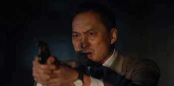 Movie still from “Tokyo Vice” (2022), created by J.T. Rogers – A person holding a gun in a dark room; Close Up shot, Low angle