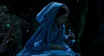Movie still from “Tom Thumb” (2001), directed by Olivier Dahan – A young girl in a blue dress and a blue robe; Medium shot, High angle