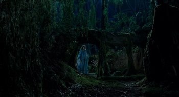 Movie still from “Tom Thumb” (2001), directed by Olivier Dahan – A woman in a blue dress standing next to a tree; Extreme Wide shot, High angle