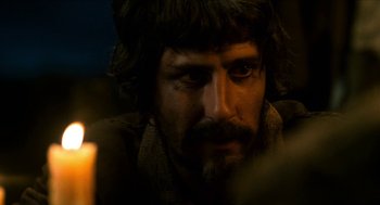 Movie still from “Tom Thumb” (2001), directed by Olivier Dahan – A person with a candle in the dark; Close Up shot, Over the shoulder angle