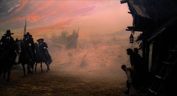 Movie still from “Tom Thumb” (2001), directed by Olivier Dahan – An image of a man riding a horse in the wild west; Extreme Wide shot, Low angle