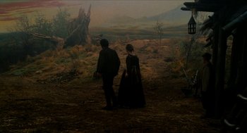 Movie still from “Tom Thumb” (2001), directed by Olivier Dahan – A man and a woman standing next to each other in a field; Wide shot, High angle