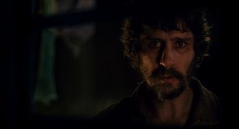 Movie still from “Tom Thumb” (2001), directed by Olivier Dahan – A person with a beard looking at the camera; Close Up shot, Over the shoulder angle