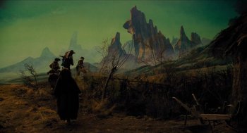 Movie still from “Tom Thumb” (2001), directed by Olivier Dahan – A painting of two people walking through a field; Wide shot, High angle