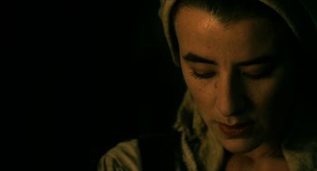 Movie still from “Tom Thumb” (2001), directed by Olivier Dahan – A person with a hat on looking down; Close Up shot, Over the shoulder angle