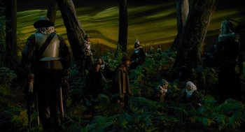 Movie still from “Tom Thumb” (2001), directed by Olivier Dahan – A group of people standing in the woods; Wide shot, High angle