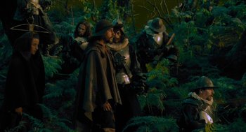 Movie still from “Tom Thumb” (2001), directed by Olivier Dahan – A group of people standing in a forest; Medium shot, Over the shoulder angle