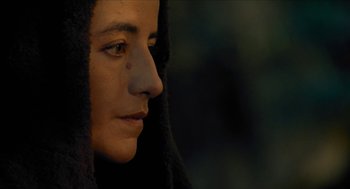 Movie still from “Tom Thumb” (2001), directed by Olivier Dahan – A person wearing a hooded jacket; Close Up shot, Over the shoulder angle