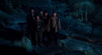 Movie still from “Tom Thumb” (2001), directed by Olivier Dahan – A group of people standing on top of a hill; Wide shot, High angle