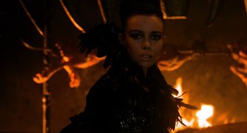 Movie still from “Tom Thumb” (2001), directed by Olivier Dahan – A woman in a black jacket and feathers; Close Up shot, Low angle