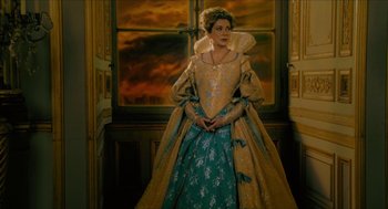 Movie still from “Tom Thumb” (2001), directed by Olivier Dahan – A woman dressed as a queen standing in front of a window; Medium shot, Low angle