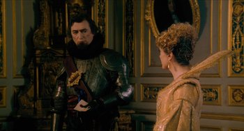 Movie still from “Tom Thumb” (2001), directed by Olivier Dahan – A man and a woman dressed in medieval garb in front of a mirror; Medium shot, Over the shoulder angle