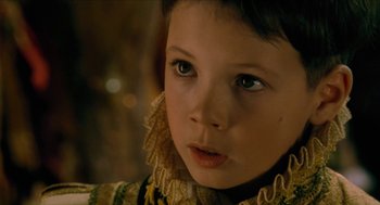Movie still from “Tom Thumb” (2001), directed by Olivier Dahan – A young child wearing a dress; Close Up shot, Over the shoulder angle