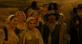 Movie still from “Tom Thumb” (2001), directed by Olivier Dahan – A large group of people standing together in a field; Wide shot, Low angle