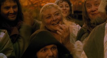 Movie still from “Tom Thumb” (2001), directed by Olivier Dahan – A group of people sitting in a room together; Close Up shot, High angle