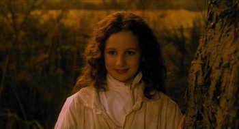 Movie still from “Tom Thumb” (2001), directed by Olivier Dahan – A young girl with long curly red hair wearing a white jacket; Close Up shot, Over the shoulder angle