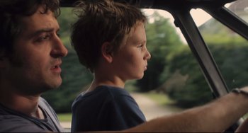 Movie still from “Tomboy” (2011), directed by Céline Sciamma – A young boy sitting in the passenger seat of a car; Close Up shot, Over the shoulder angle