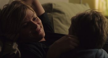 Movie still from “Tomboy” (2011), directed by Céline Sciamma – A man laying on a couch with his arm around a woman; Close Up shot, Over the shoulder angle