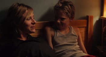 Movie still from “Tomboy” (2011), directed by Céline Sciamma – A woman and a boy sitting next to each other on a bench; Medium shot, Over the shoulder angle