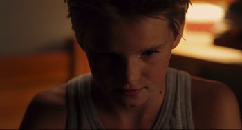 Movie still from “Tomboy” (2011), directed by Céline Sciamma – A young man's face in the dark; Close Up shot, High angle