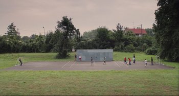 Movie still from “Tomboy” (2011), directed by Céline Sciamma – A group of people playing a game of tennis in a park; Extreme Wide shot, High angle