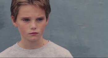 Movie still from “Tomboy” (2011), directed by Céline Sciamma – A young boy is looking into the camera; Close Up shot, High angle
