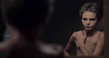 Movie still from “Tomboy” (2011), directed by Céline Sciamma – A woman is sitting in front of a bathroom mirror; Close Up shot, Over the shoulder angle