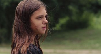Movie still from “Tomboy” (2011), directed by Céline Sciamma – A young girl with long brown hair looking to her left; Close Up shot, Over the shoulder angle