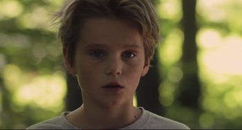 Movie still from “Tomboy” (2011), directed by Céline Sciamma – A young boy with a blurry background; Close Up shot, Over the shoulder angle