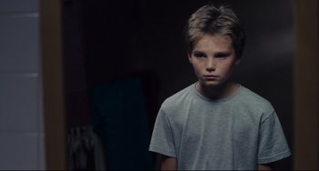 Movie still from “Tomboy” (2011), directed by Céline Sciamma – A young boy in a gray shirt is looking at the camera; Close Up shot, Low angle