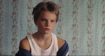 Movie still from “Tomboy” (2011), directed by Céline Sciamma – A young boy in a white shirt and a blue shirt; Close Up shot, High angle