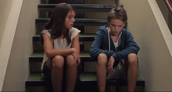 Movie still from “Tomboy” (2011), directed by Céline Sciamma – Two young girls sitting on a set of stairs; Medium shot, High angle