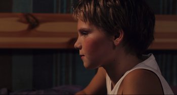 Movie still from “Tomboy” (2011), directed by Céline Sciamma – A young boy sitting in front of a wooden wall; Close Up shot, Over the shoulder angle