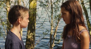Movie still from “Tomboy” (2011), directed by Céline Sciamma – Two young girls face each other in front of a body of water; Medium shot, Over the shoulder angle