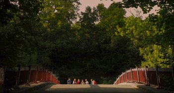 Movie still from “Tomboy” (2011), directed by Céline Sciamma – A group of people sitting on the side of a road; Extreme Wide shot, High angle