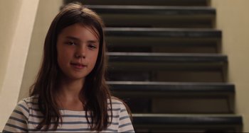 Movie still from “Tomboy” (2011), directed by Céline Sciamma – A young girl is standing in front of some stairs; Close Up shot, Low angle