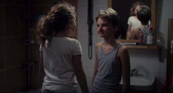 Movie still from “Tomboy” (2011), directed by Céline Sciamma – Two young children standing next to each other in front of a bathroom mirror; Close Up shot, Over the shoulder angle