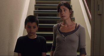 Movie still from “Tomboy” (2011), directed by Céline Sciamma – A woman standing next to a boy in front of a staircase; Medium shot, Low angle