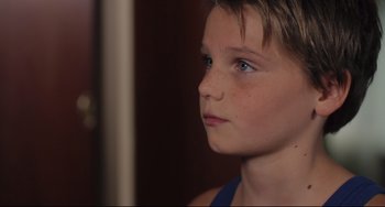 Movie still from “Tomboy” (2011), directed by Céline Sciamma – A young boy's face with blue eyes; Close Up shot, Over the shoulder angle