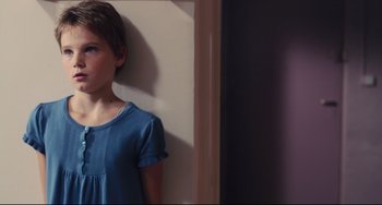 Movie still from “Tomboy” (2011), directed by Céline Sciamma – A young girl standing in front of a white wall; Close Up shot, Over the shoulder angle
