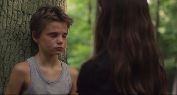 Movie still from “Tomboy” (2011), directed by Céline Sciamma – A young man and a young woman sitting next to a tree; Close Up shot, Over the shoulder angle