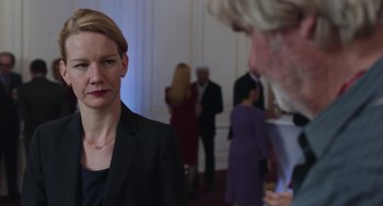 A woman standing next to a man in a suit